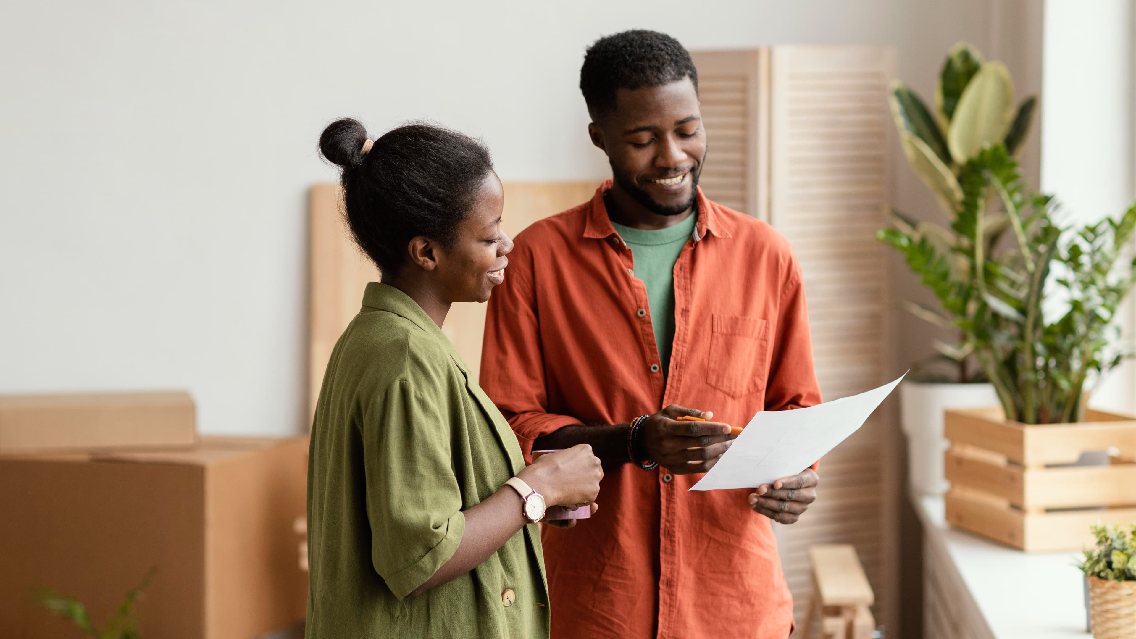Happy couple planning on redecorating house looking over paperwork
