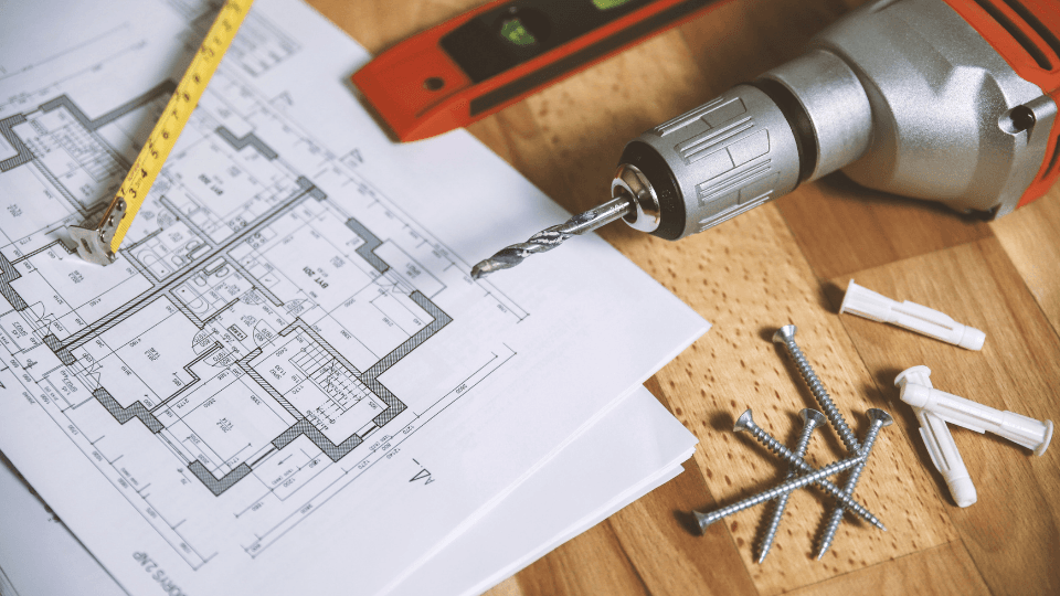 Tools and screws over the house plan